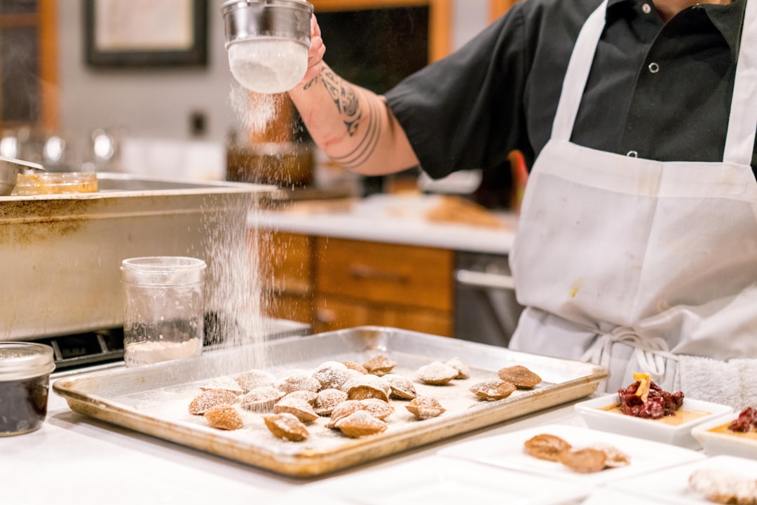 Baker hand-piping doughnut fillings in kitchen