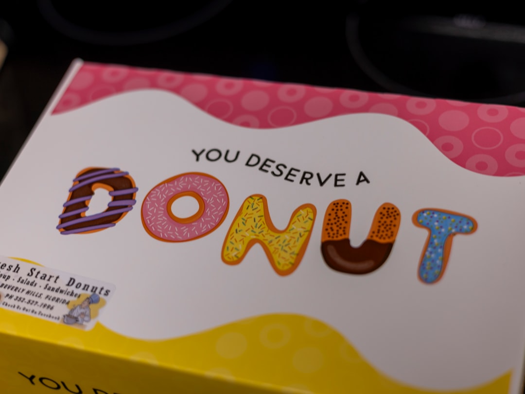 Open box revealing assorted colourful handcrafted doughnuts